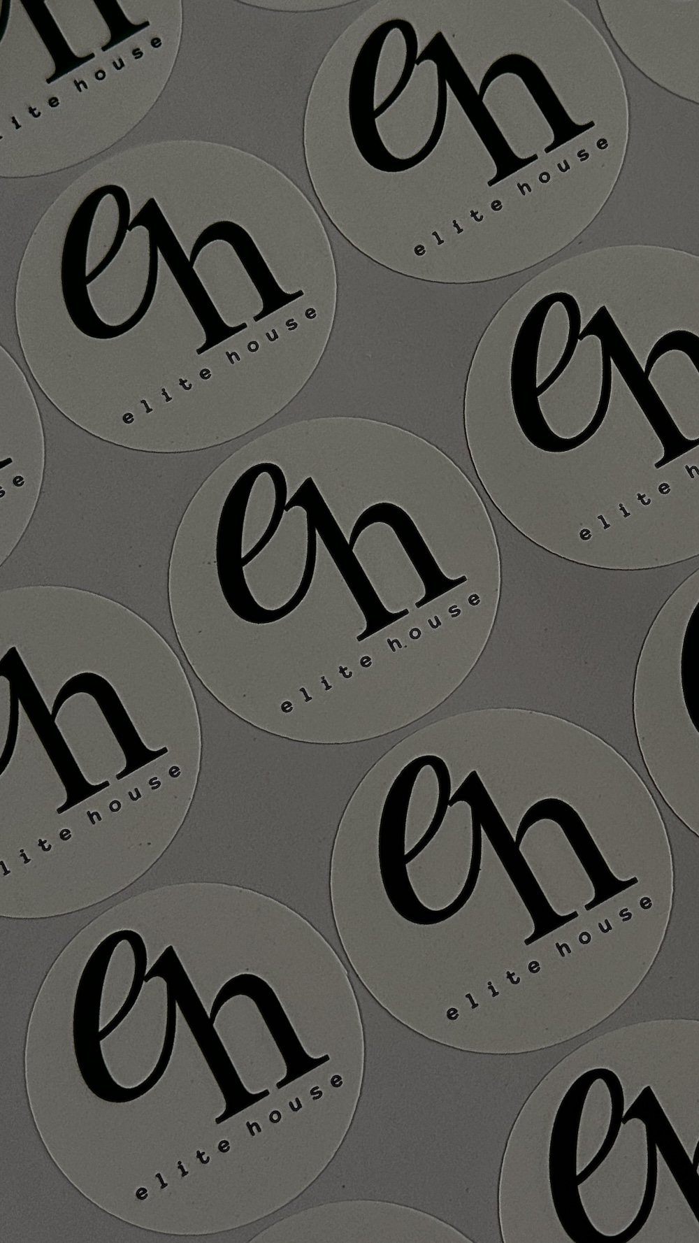 Een vel ronde stickers met het eh elite house logo