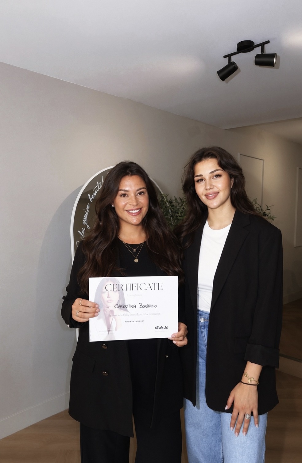 Christina met een cursist die haar certificaat laat zien, in de salon